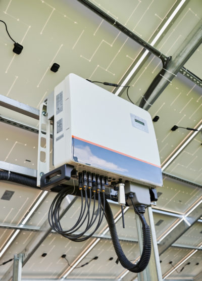 Smart Solar Inverter for High-Efficiency Residential Solar Systems smart solar inverter mounted beneath rooftop solar panels for efficient residential solar energy conversion and real-time system monitoring